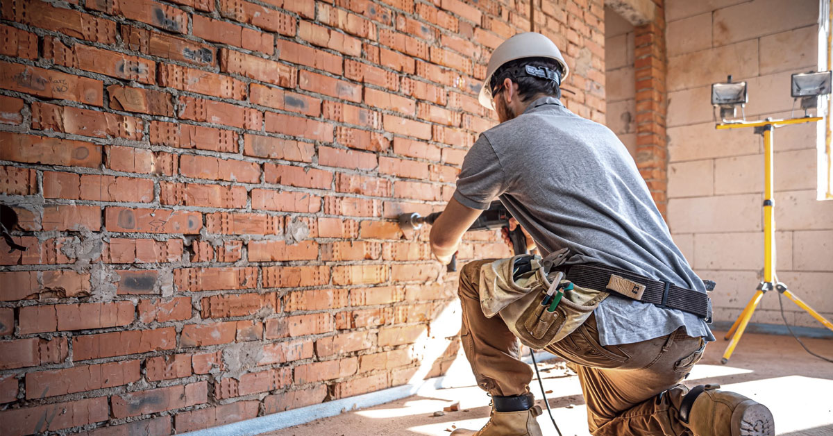 hombre taladrando una pared en construccion
