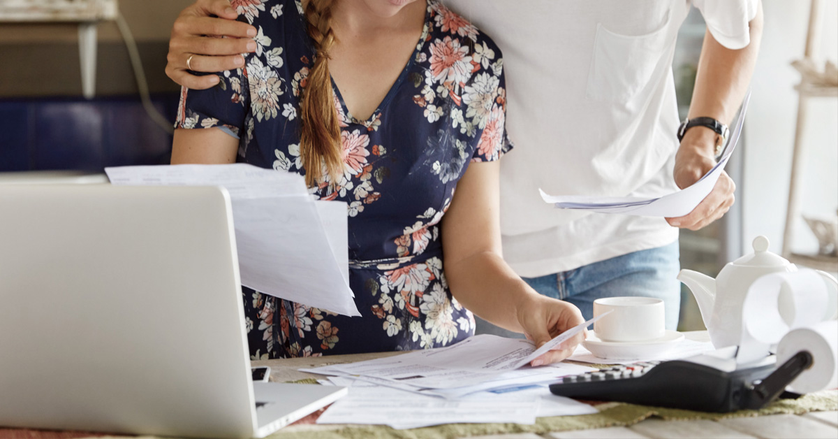 pareja mirando documentos con una calculadora